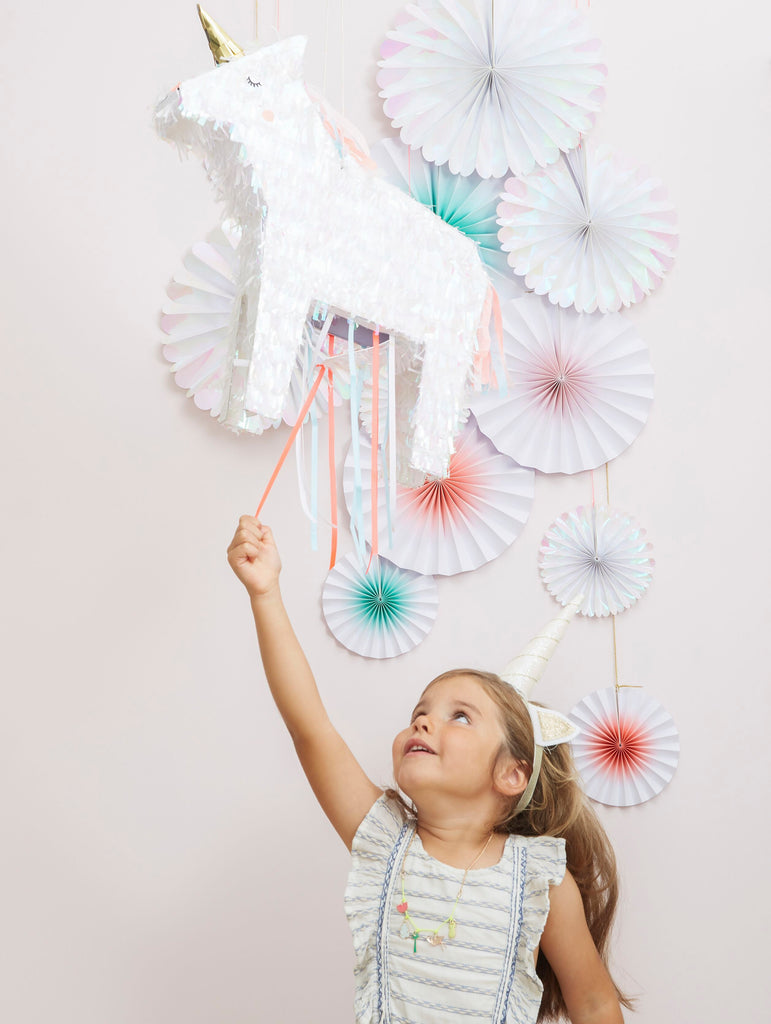 little girls birthday party, playing with unicorn party piñata at birthday party. Made by Meri Meri