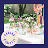 fairy garden birthday party table setting with white paper and coral grid tablecloth made by Meri Meri